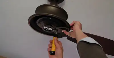 Electrician installing ceiling fan mounting bracket and fixture in Modesto, CA