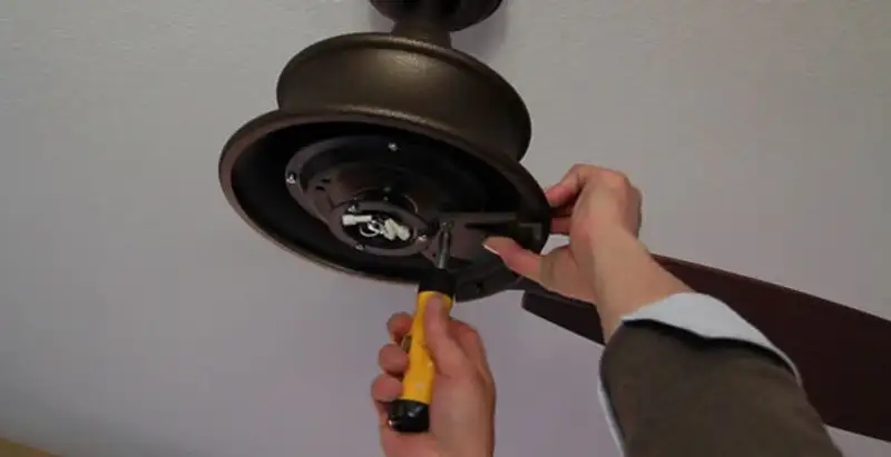Electrician installing ceiling fan mounting bracket and fixture in Modesto, CA