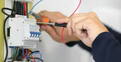 Electrician installing and adjusting circuit breakers in an electrical panel in Modesto, CA