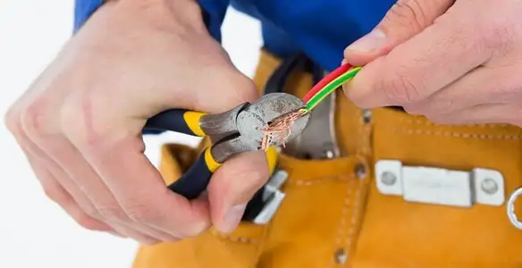 licensed electrician securing electrical wiring with professional tools during service work in Modesto, CA