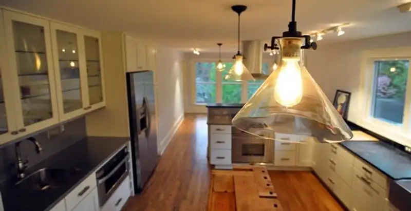 Residential electrician installing modern indoor light fixture in a home in Modesto, CA